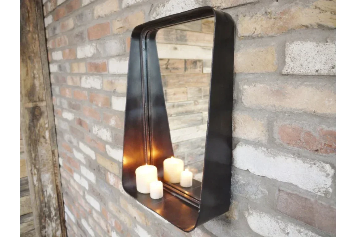 Black metal wall mirror shelf with candles against exposed brick wall