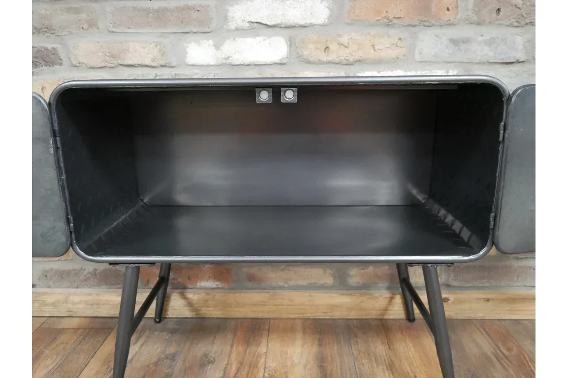 Industrial black metal storage cabinet with open doors on wooden floor against brick wall