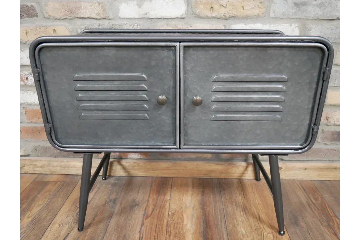 Industrial metal sideboard with double doors and black legs against a brick wall