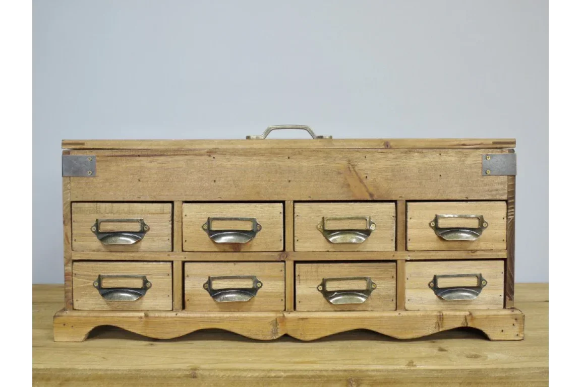 Rustic wooden storage chest with eight small drawers and metal handles on wooden surface