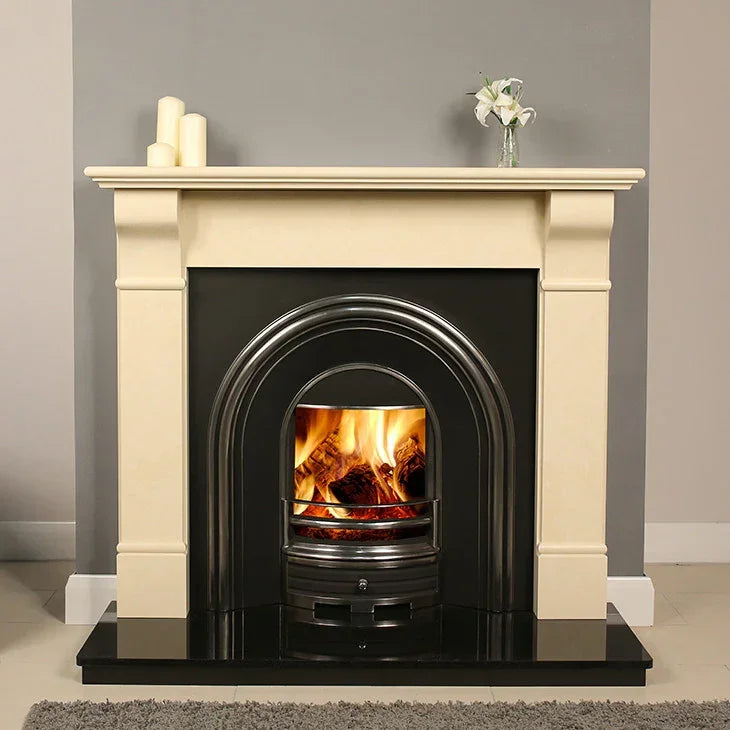 Ivory cream fireplace surround with black insert and real fire, styled with candles and flowers
