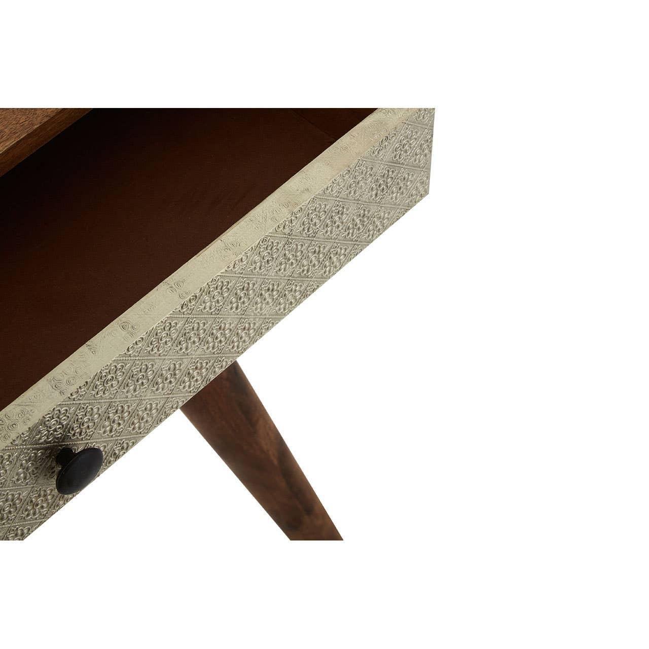 Closeup of wooden side table with embossed drawer front and angled leg