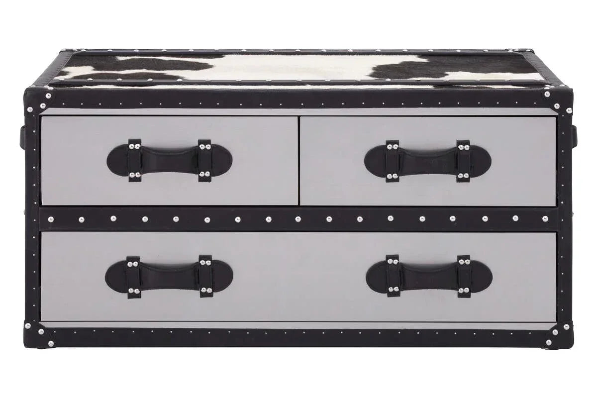 Trunk style storage coffee table with black and white cowhide top and rivet details
