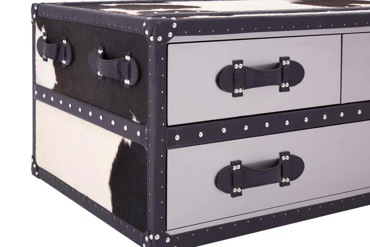 Cowhide trunk chest with black and white pattern, leather handles, metal stud accents