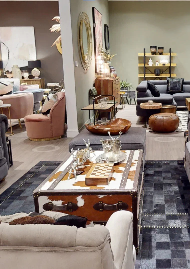 Cowhide trunk coffee table with chessboard, surrounded by modern living room furniture and décor