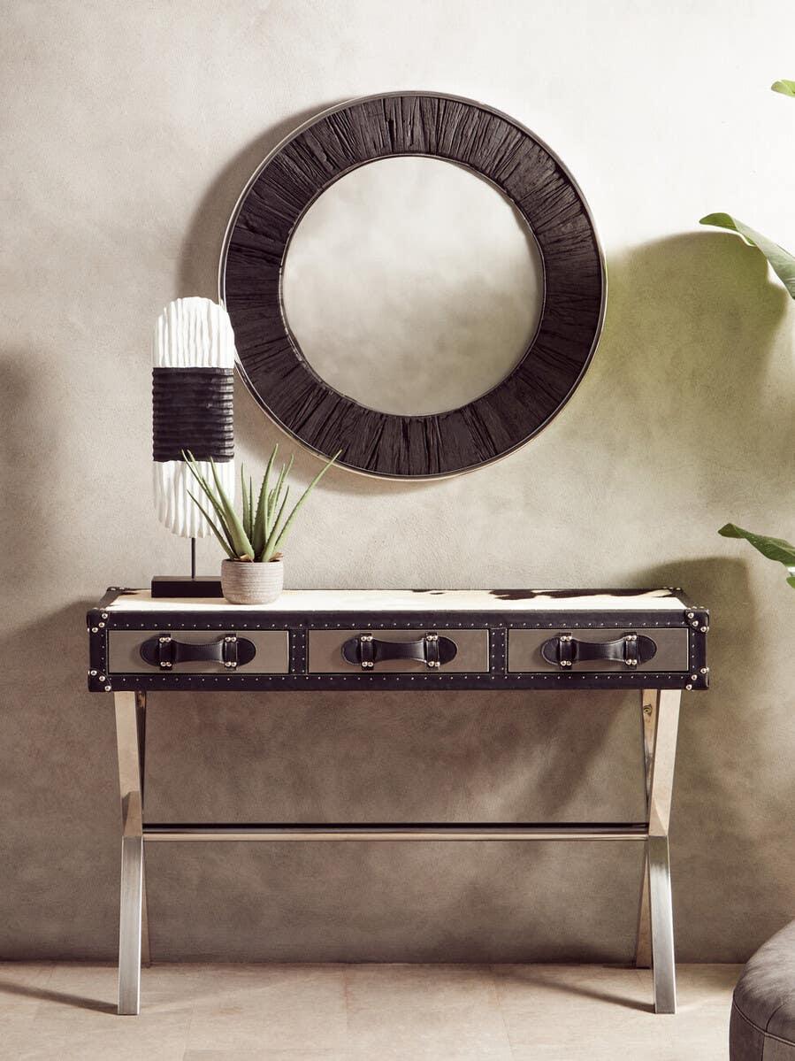 Metal and leather console table with drawers, round wall mirror, and modern decor accents