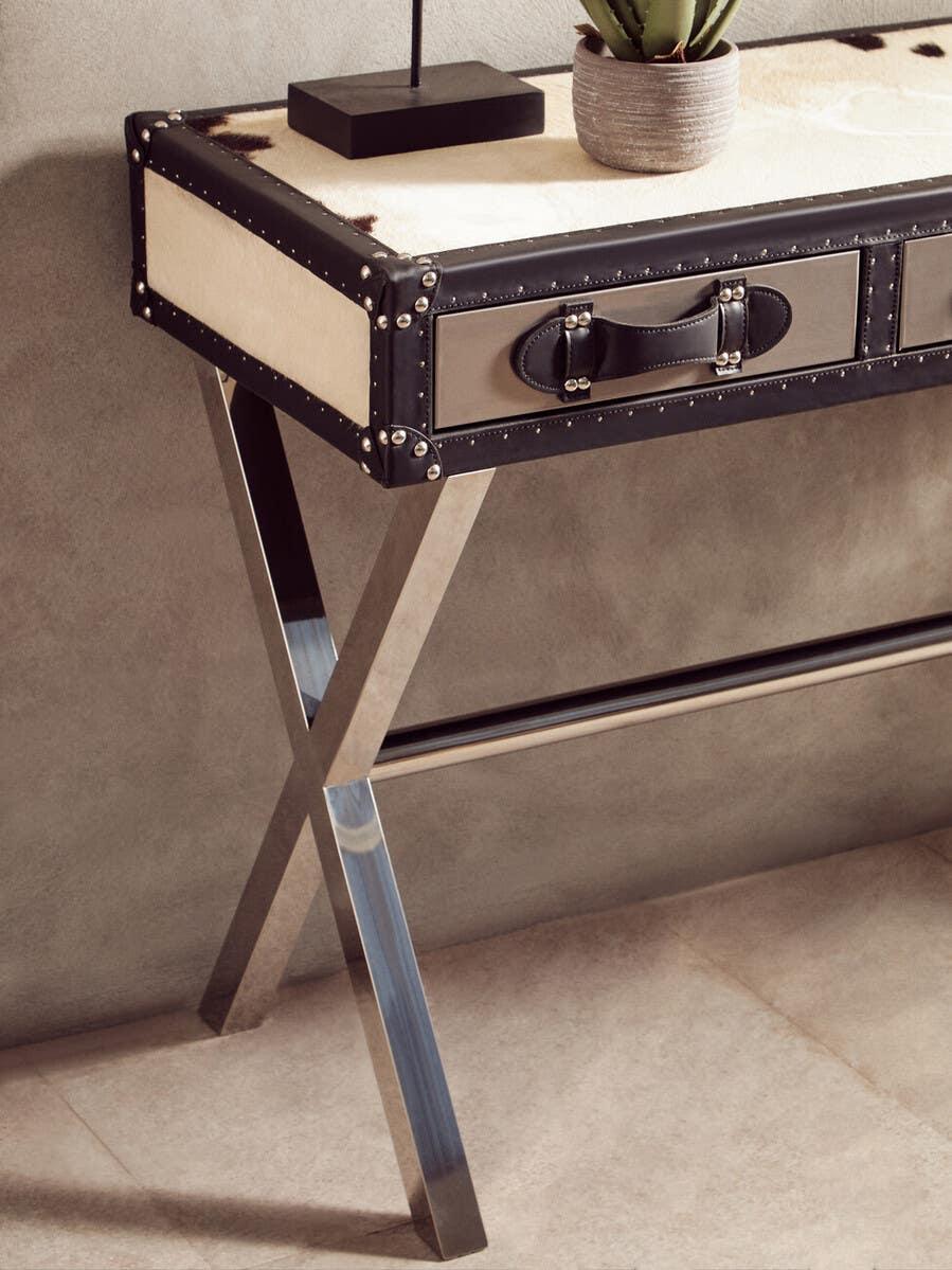 Leather and metal console table with drawer, chrome legs, and potted plant on top