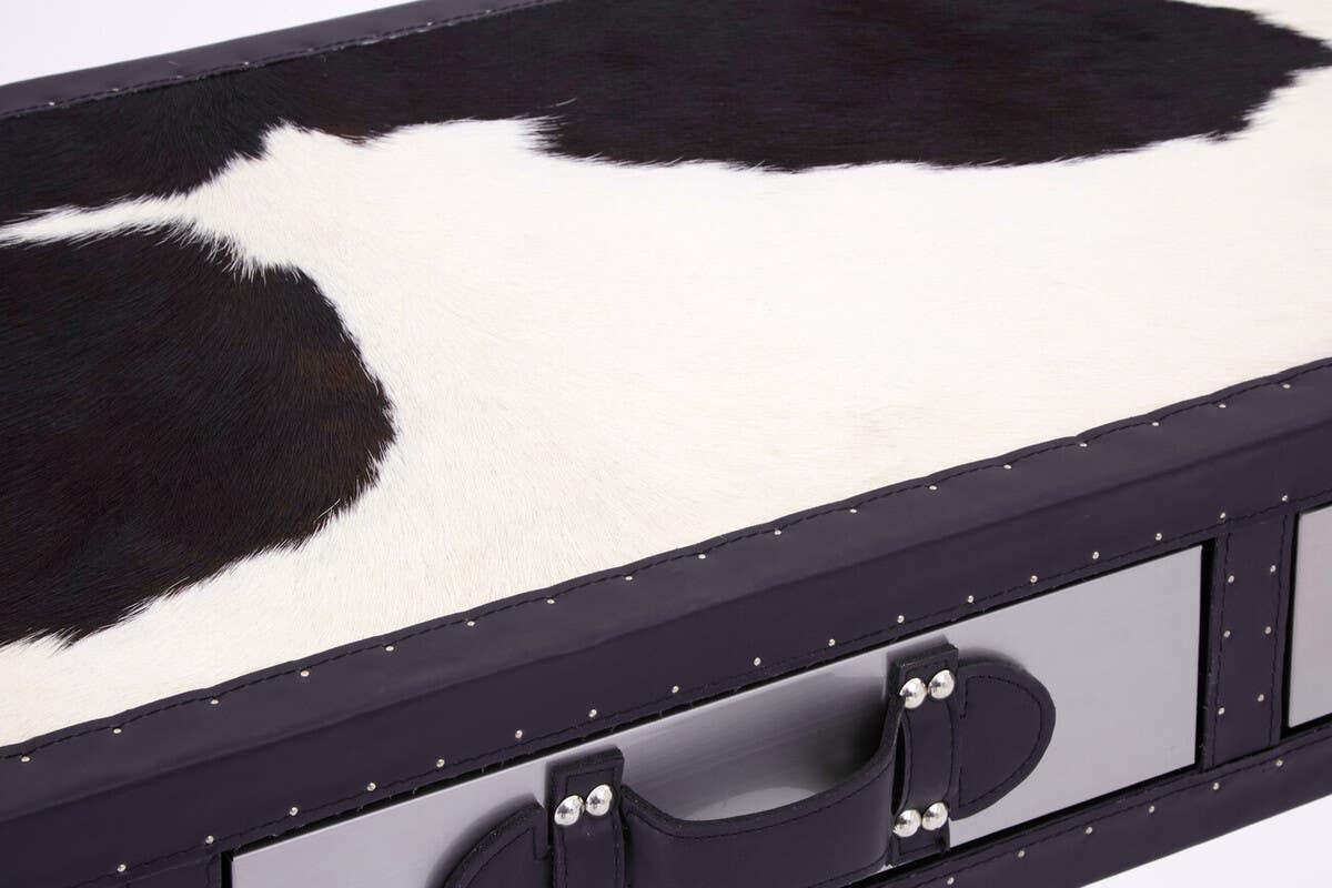 Cowhide bench with black and white pattern, close view of handle and stitched trim