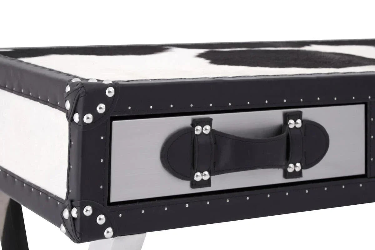 Black and white cowhide storage bench with rivet trim and faux leather handle detail