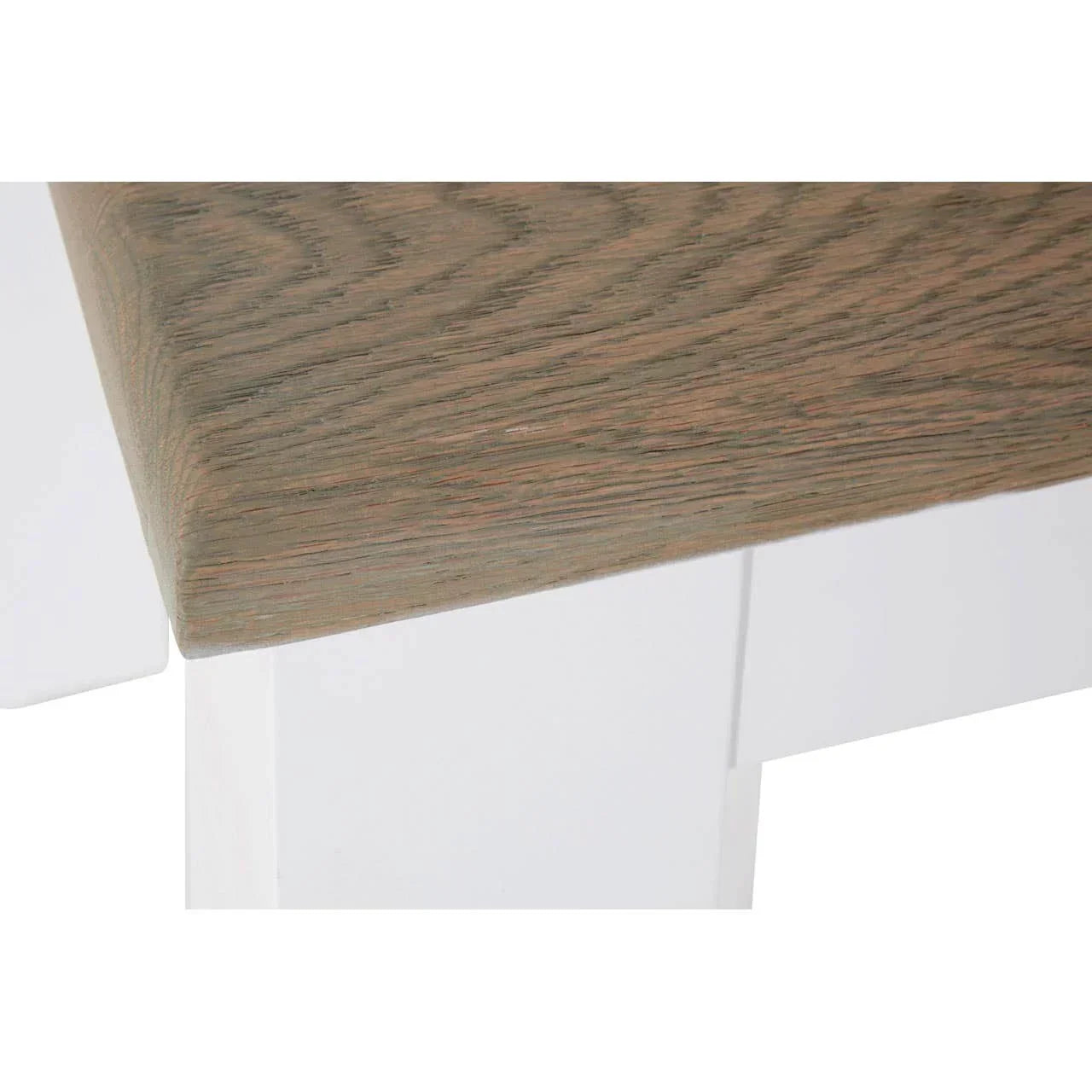 Closeup of dining table corner with light wood top and white painted legs