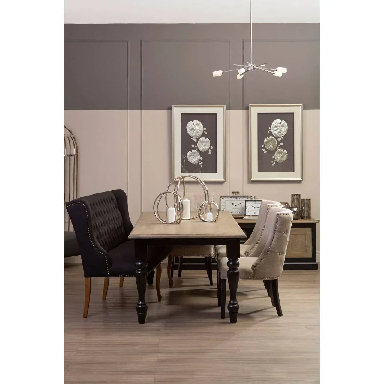 Wood dining table with studded velvet chairs and decorative centrepieces in modern dining room