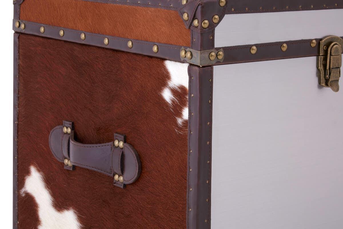 Brown and white cowhide storage trunk with leather handle and brass rivet details