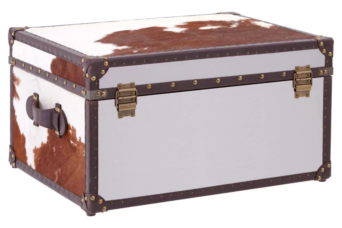 Cowhide storage trunk with brown leather trim and brass hardware, angled front view