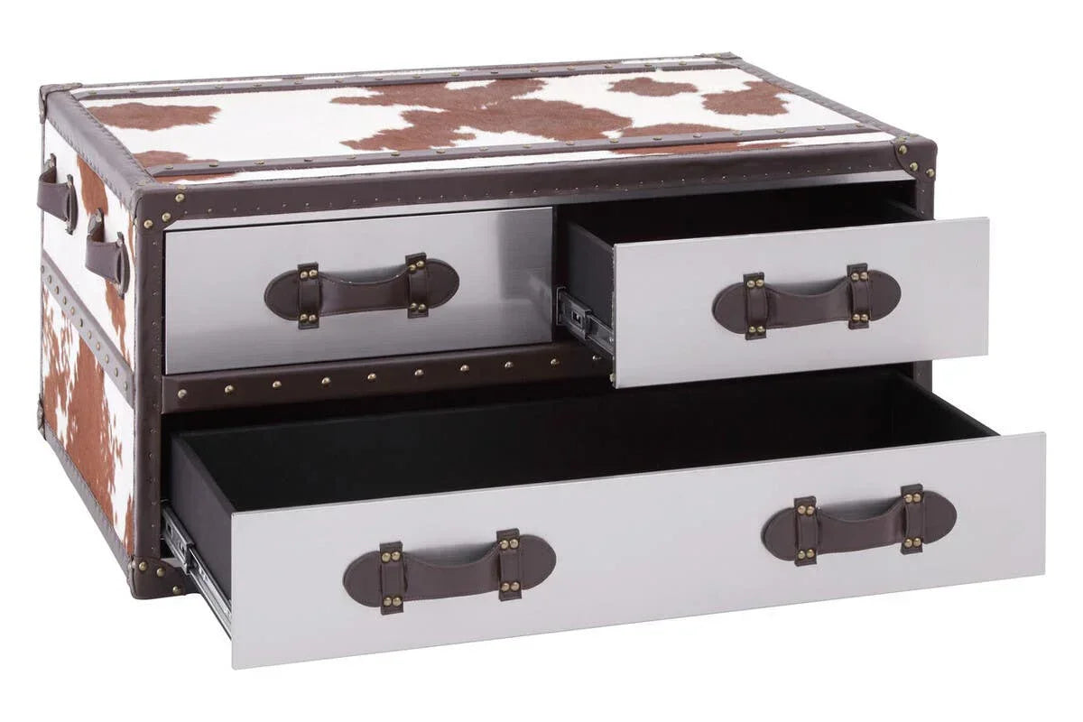 Brown and white cowhide storage trunk with open drawers and leather handles