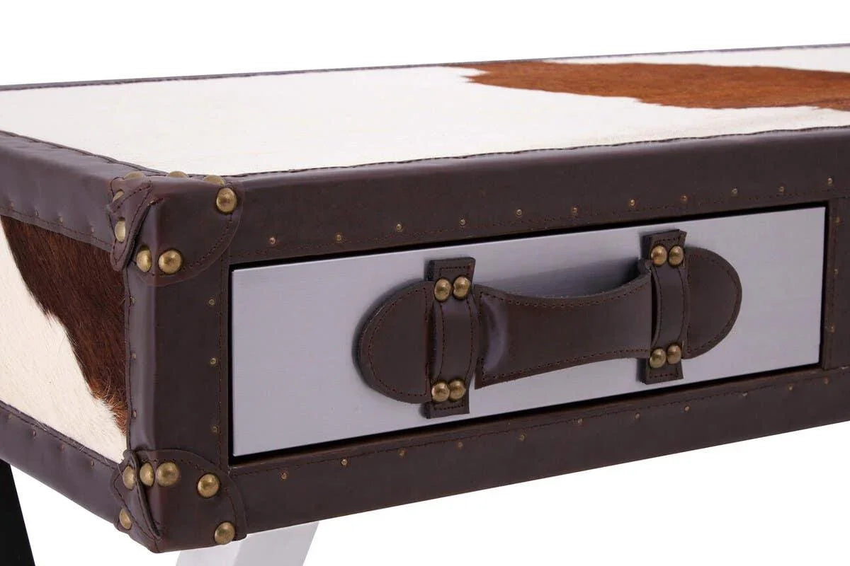 Cowhide and leather accent table corner with studded trim and drawer handle detail