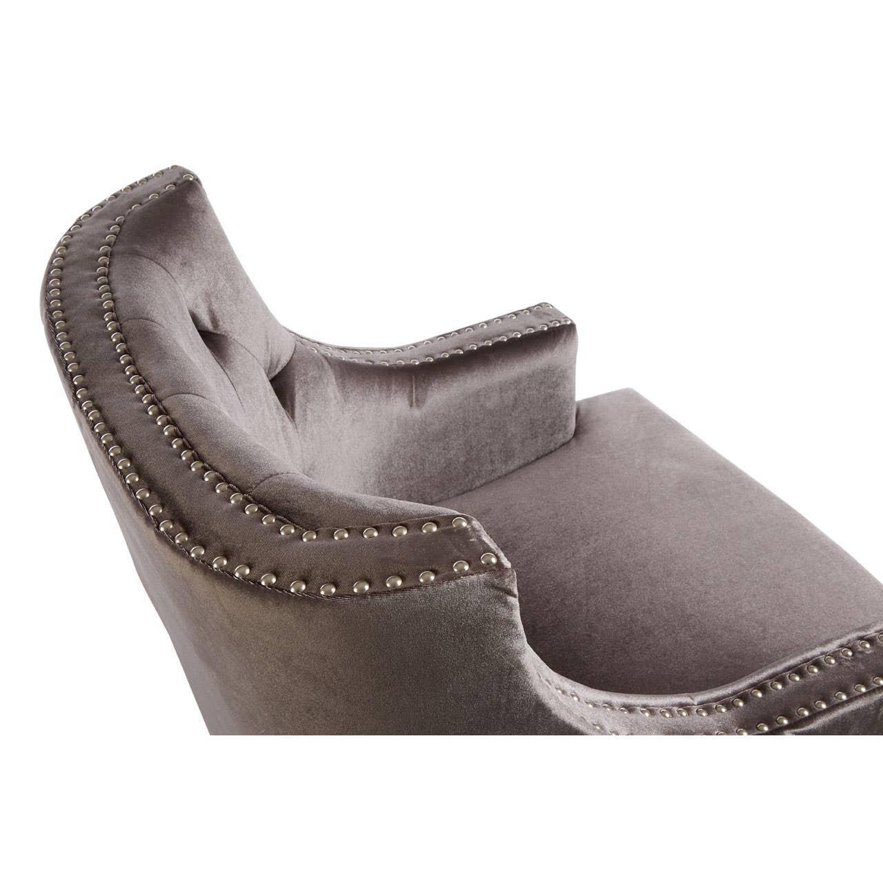 Grey velvet accent chair with silver studded trim and curved backrest close-up