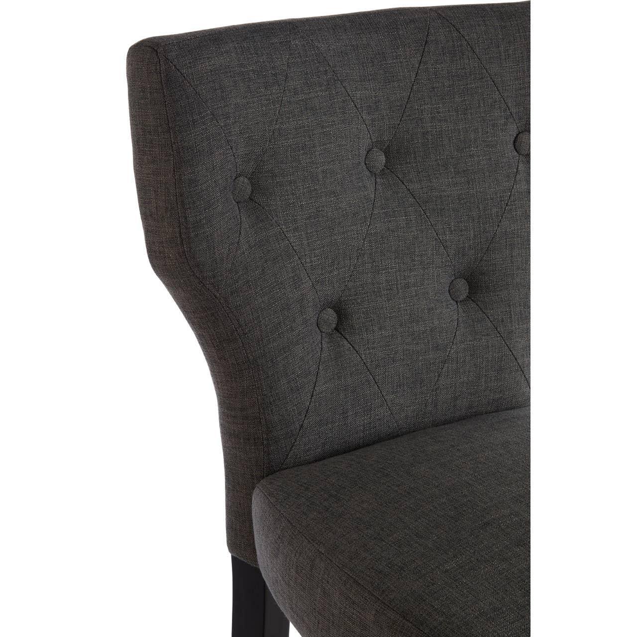 Dark grey upholstered dining chair with button-tufted backrest and textured fabric