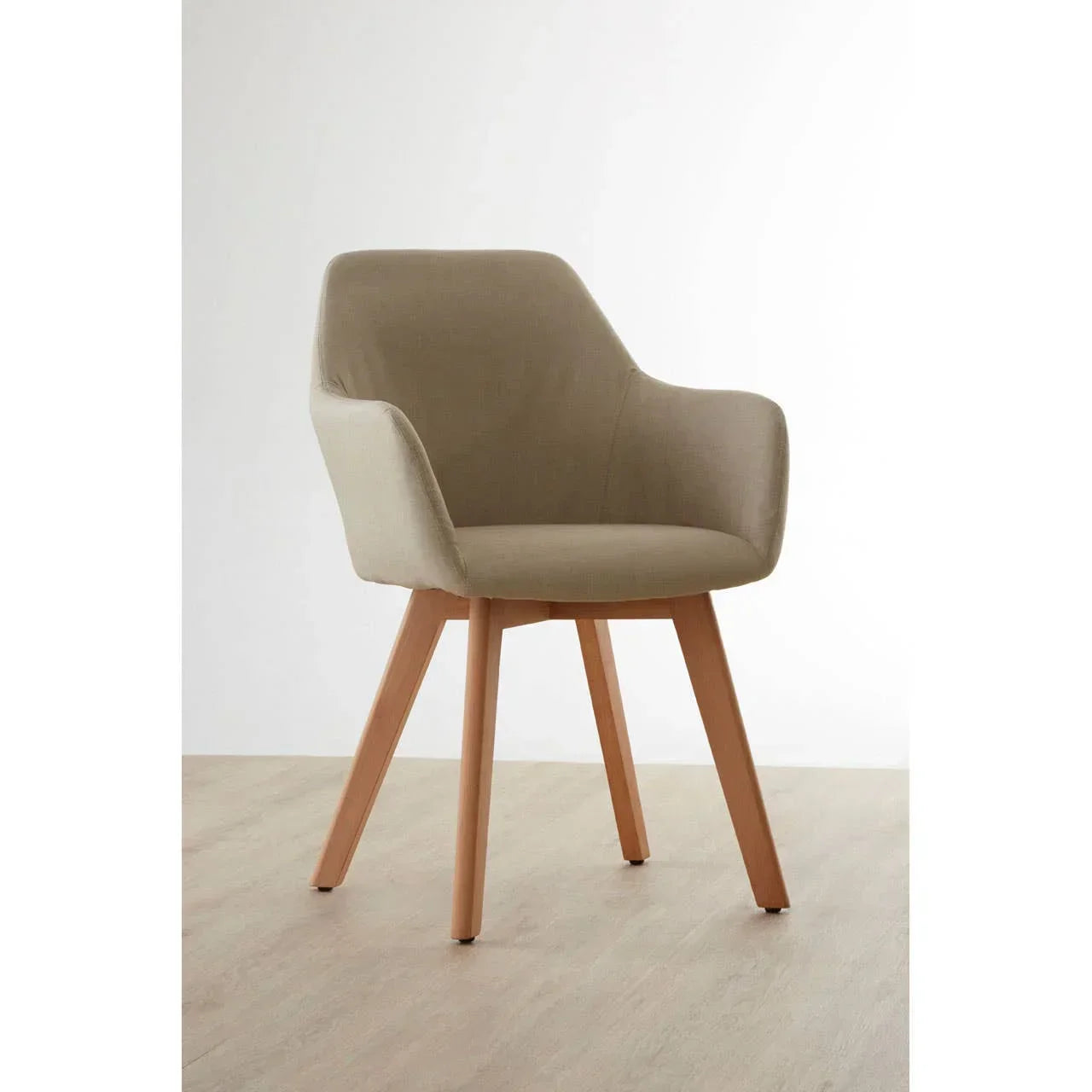 Beige fabric accent chair with wooden legs on light wood floor, angled front view