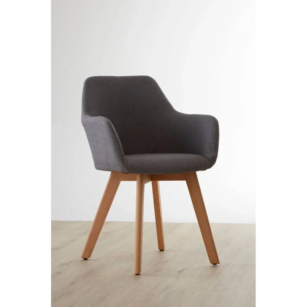 Grey upholstered dining chair with wooden legs on light wood floor