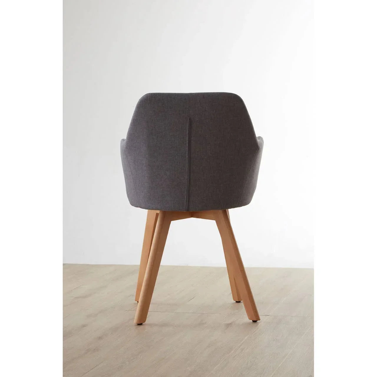 Rear view of grey fabric dining chair with wooden legs on light wood floor