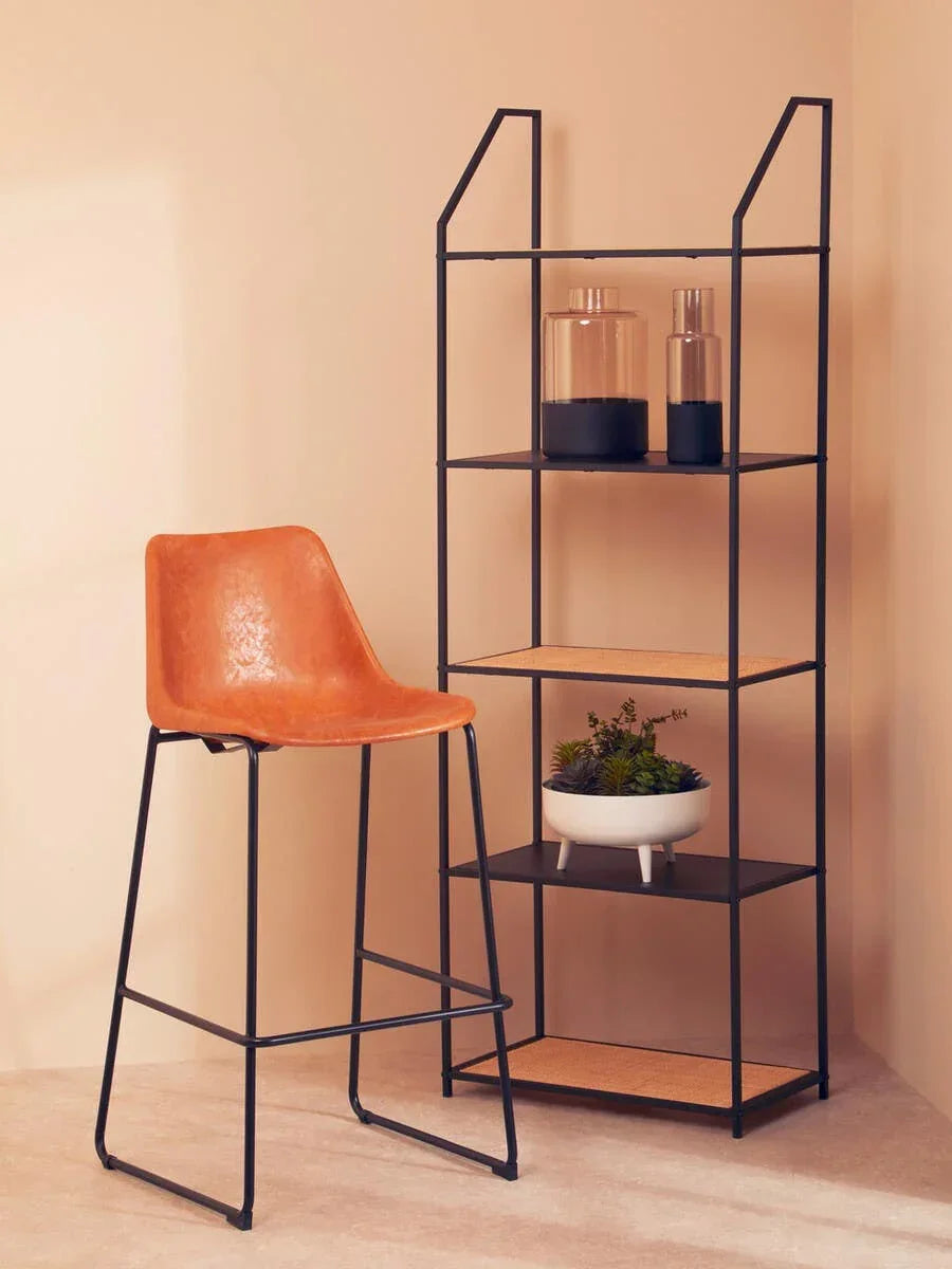 Brown faux leather bar stool with black metal legs beside black metal shelving unit