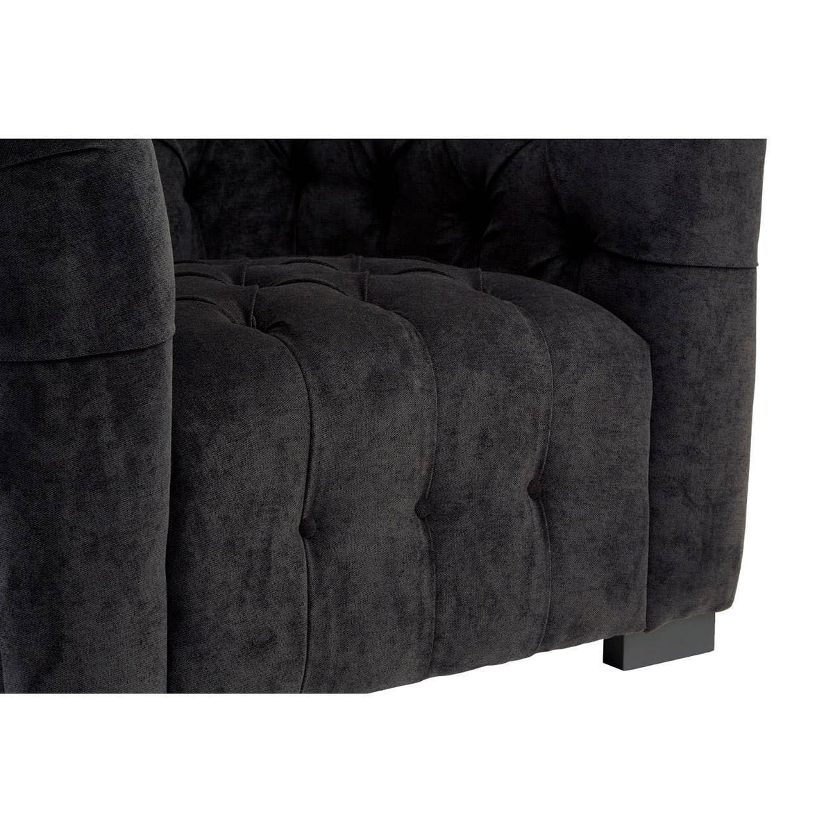 Close-up of black velvet tufted sofa arm and seat cushion