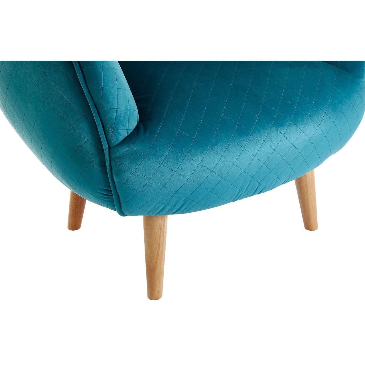 Blue accent chair with quilted upholstery and wooden legs, close-up corner view