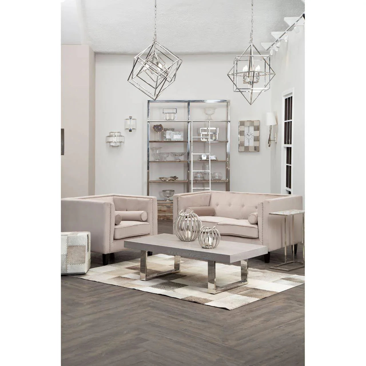 Beige tufted sofas with chrome legs, modern coffee table, shelving and geometric lighting