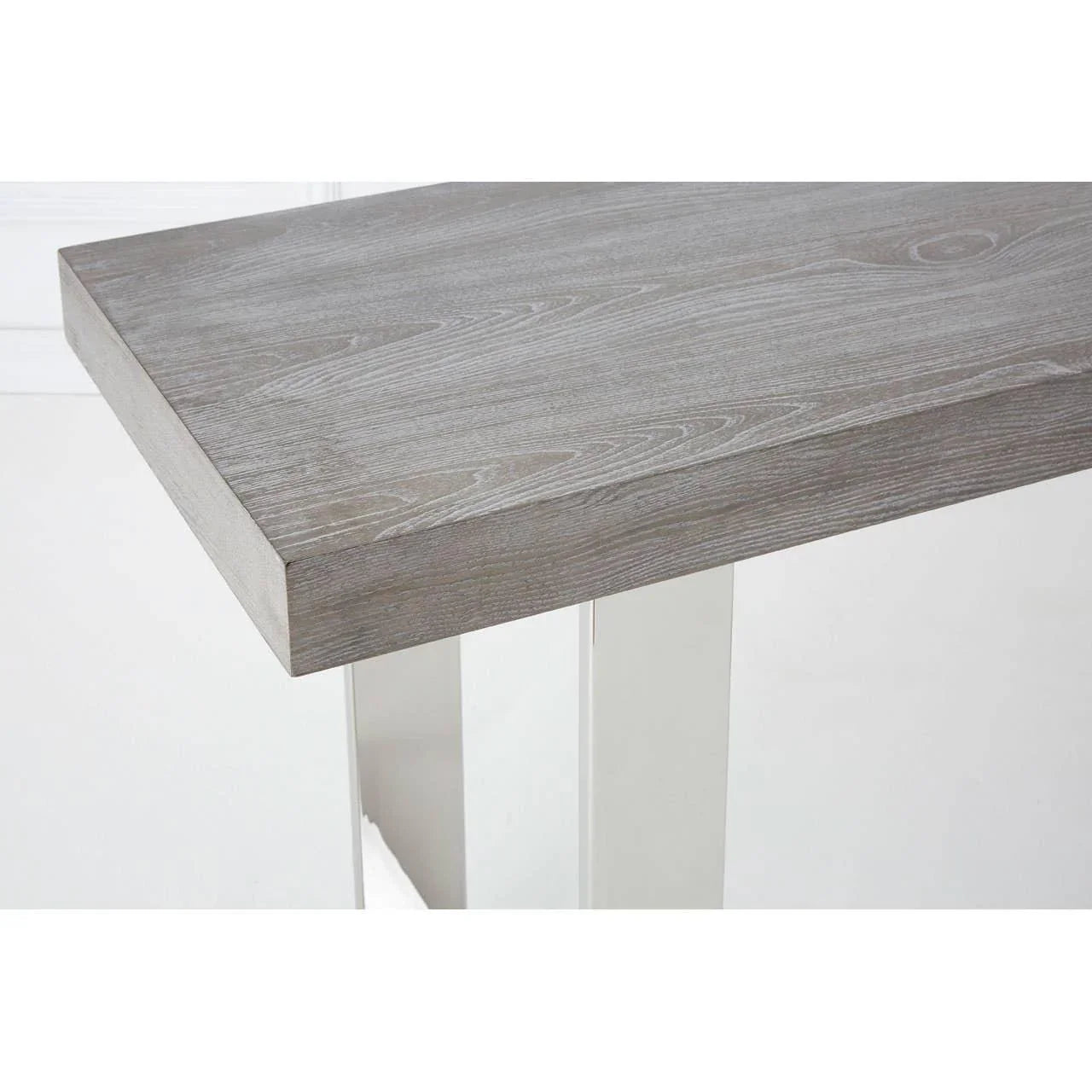 Grey wood dining table top with chrome metal legs, close-up angle