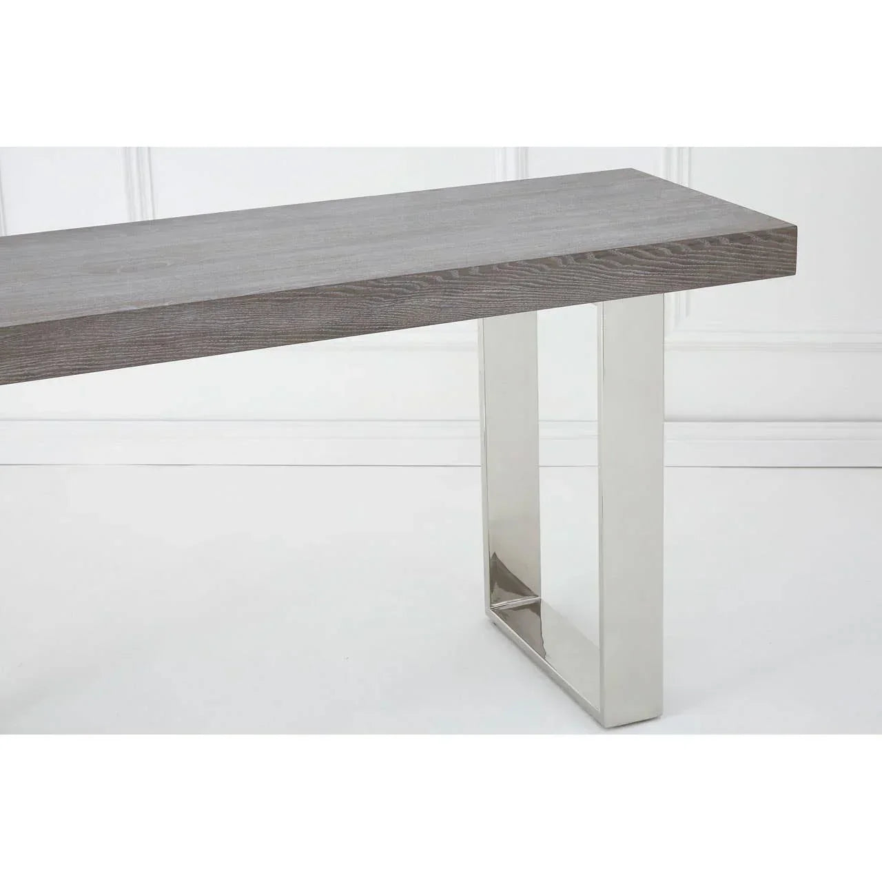 Grey wood dining table with chrome metal legs in modern room setting
