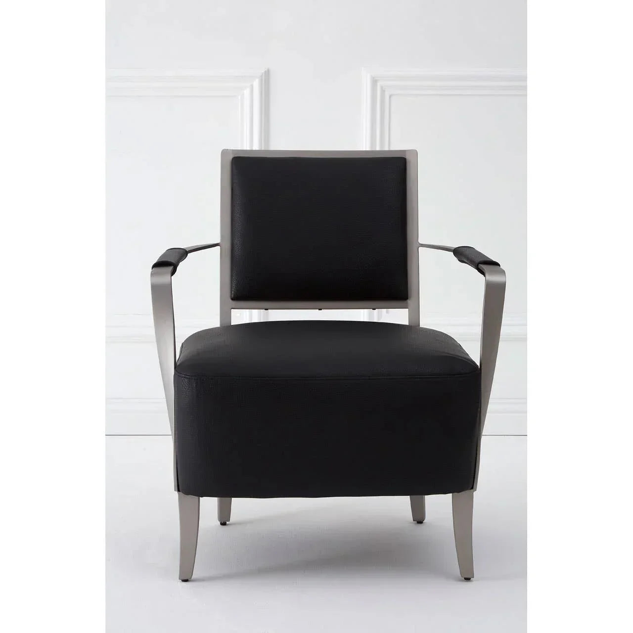 Black leather armchair with silver metal frame shown front facing against white wall