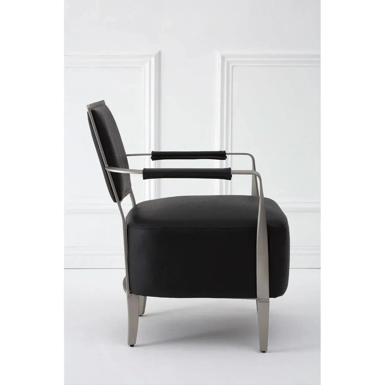 Modern accent chair with black upholstery and sleek brushed metal armrests, side view