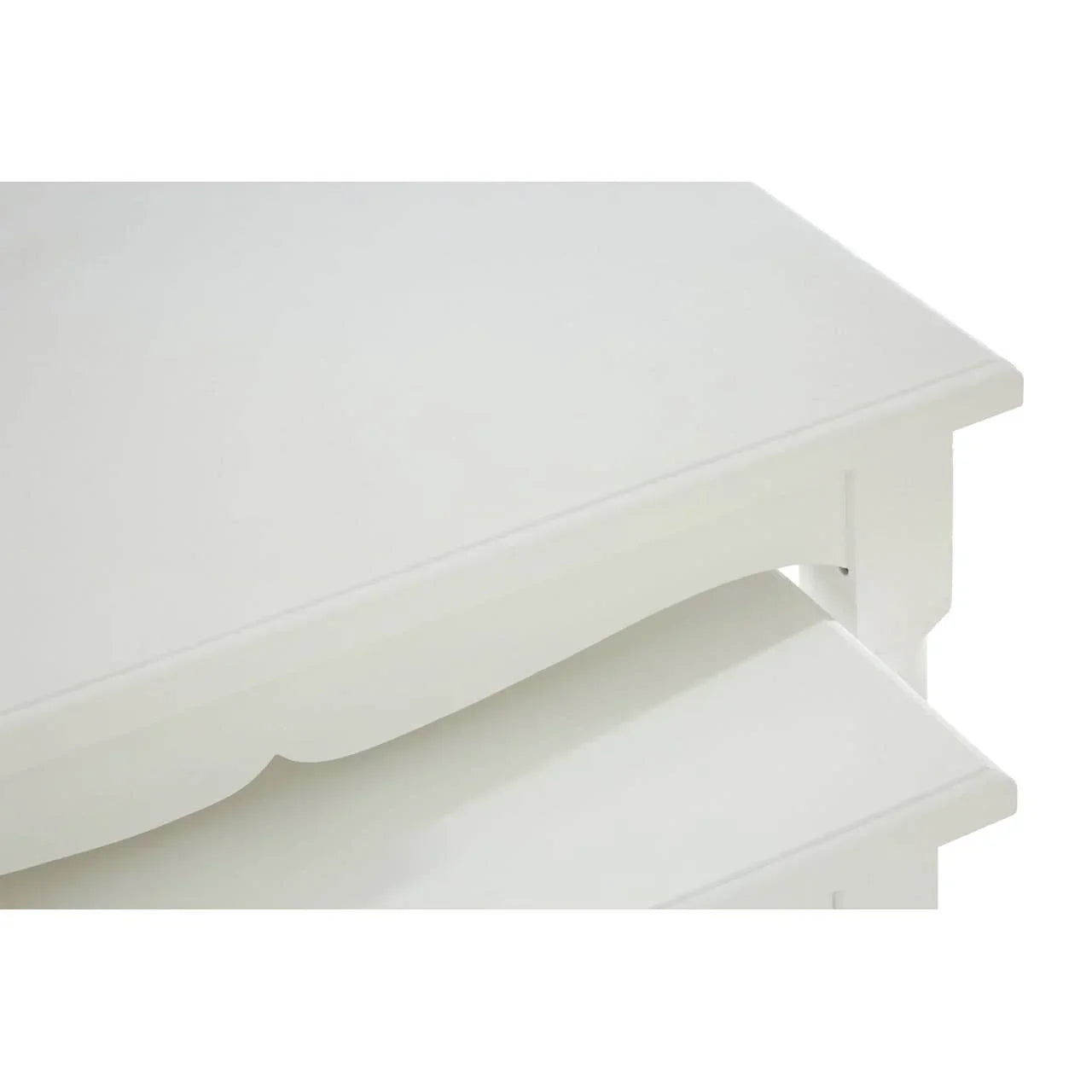 White wooden nesting tables with scalloped edge detail, close-up of tabletop corner