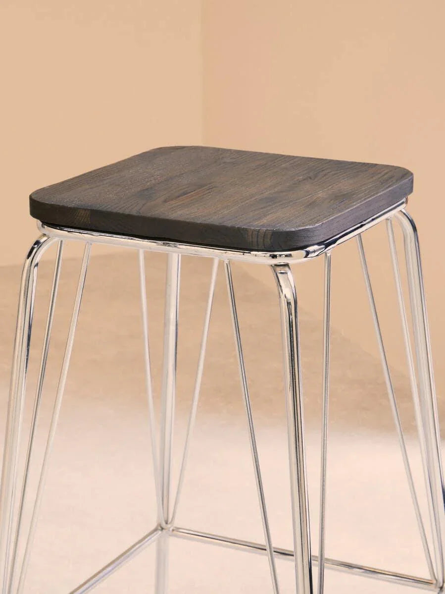 Bar stool with dark wood seat and chrome metal legs against neutral background