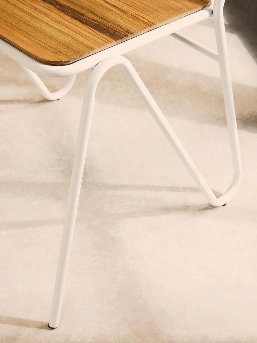 Close-up of dining table with white metal legs and wood top on light tile floor