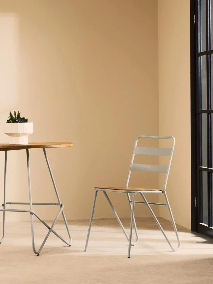 Modern dining chair with light wood seat and metal frame beside round table