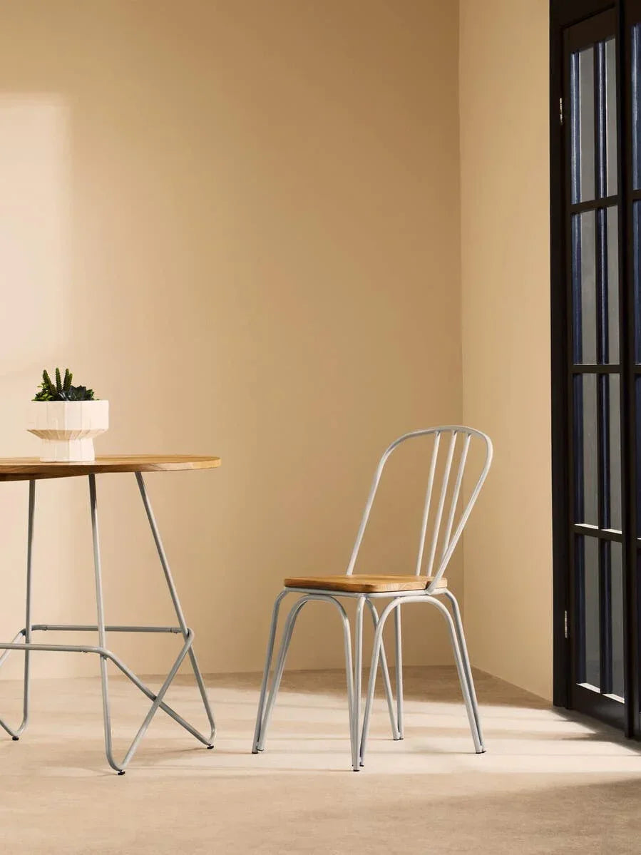 Metal dining chair with wooden seat beside matching table in modern room