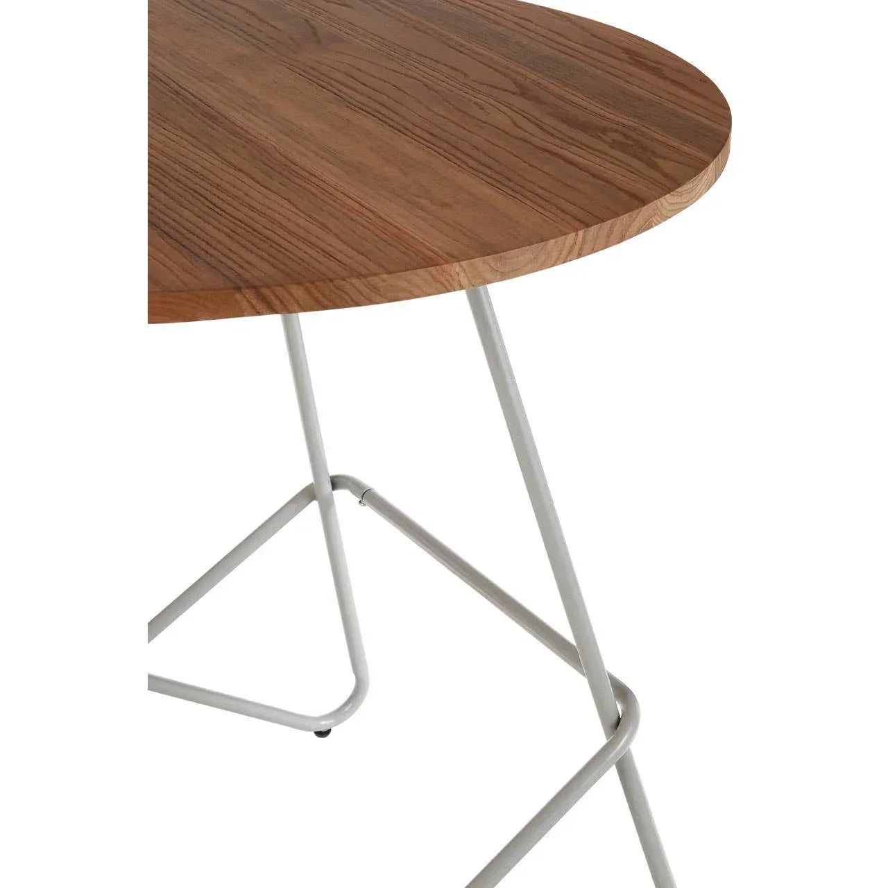 Round wooden table top with light metal legs, close view of dining table corner