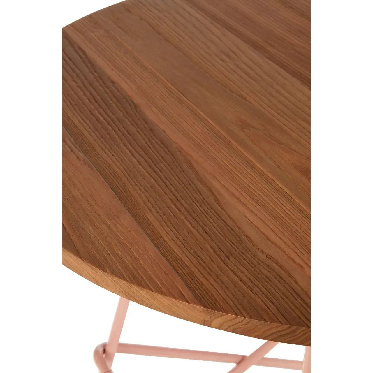 Round wooden table top with visible wood grain and light pink metal legs, close view