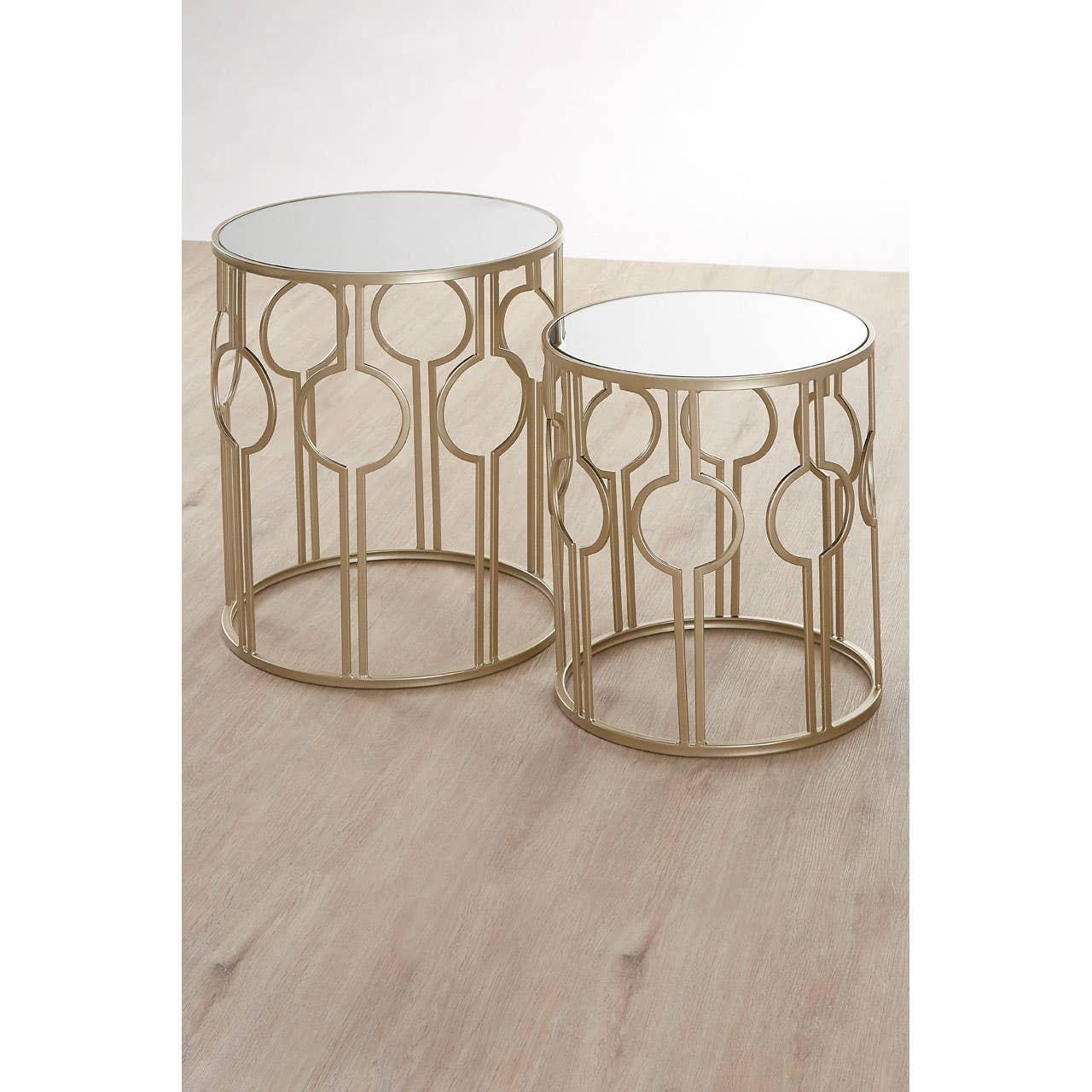 Set of two gold metal side tables with mirrored tops and geometric frames on wood floor