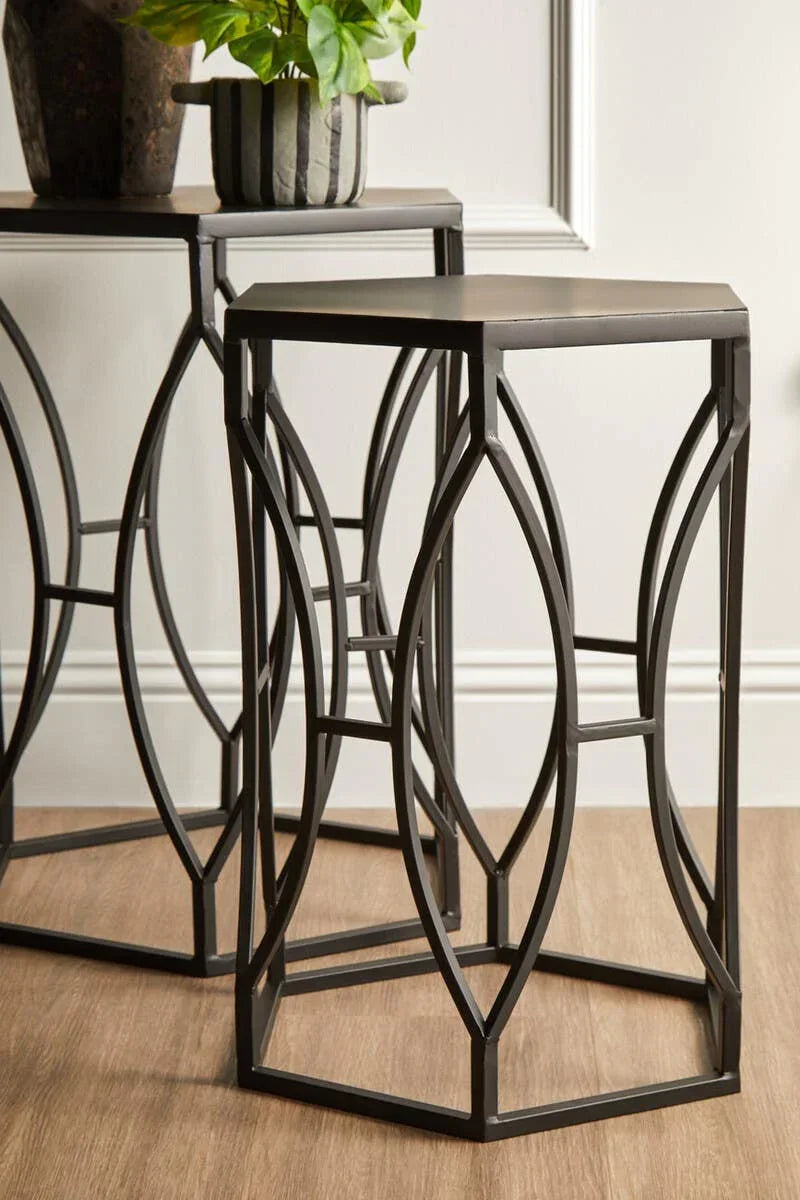 Black metal nesting tables with geometric frames on wooden floor