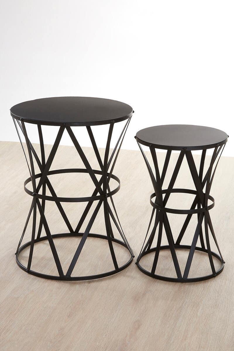 Black metal side tables with geometric bases on light wood floor