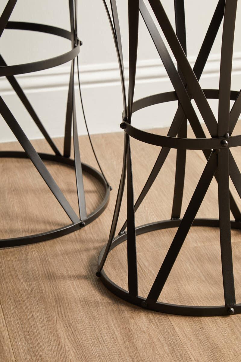 Black metal table legs with geometric design on wood floor