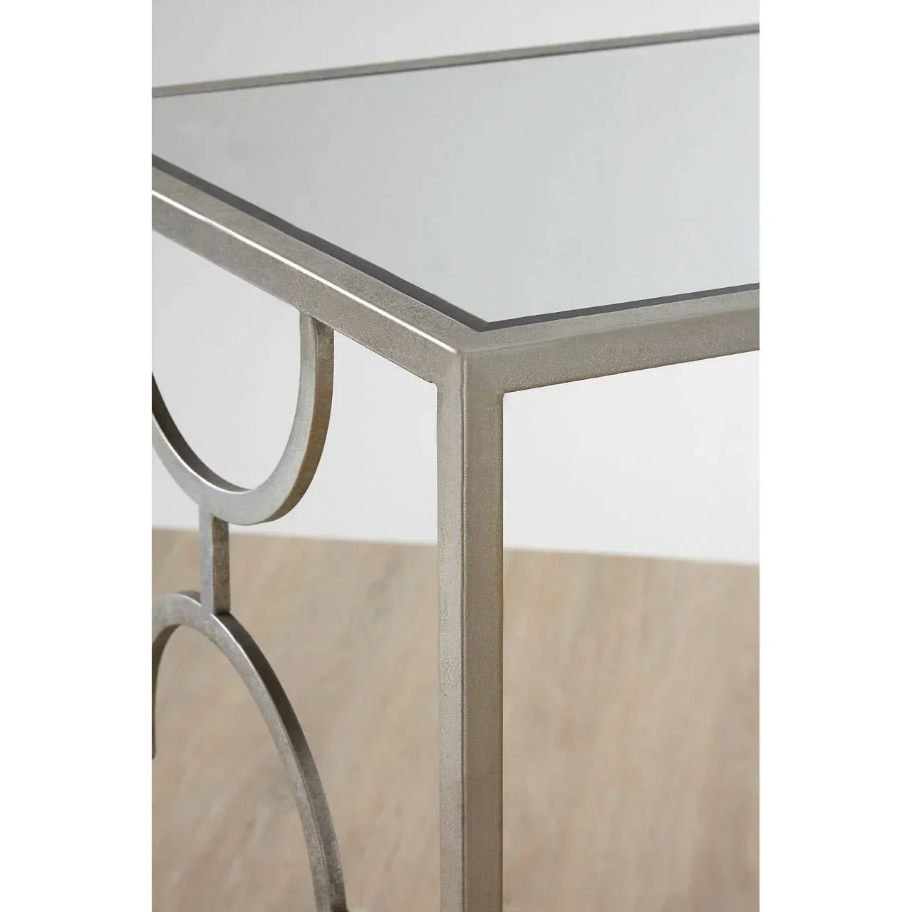 Glass top console table with silver metal frame and curved side detail