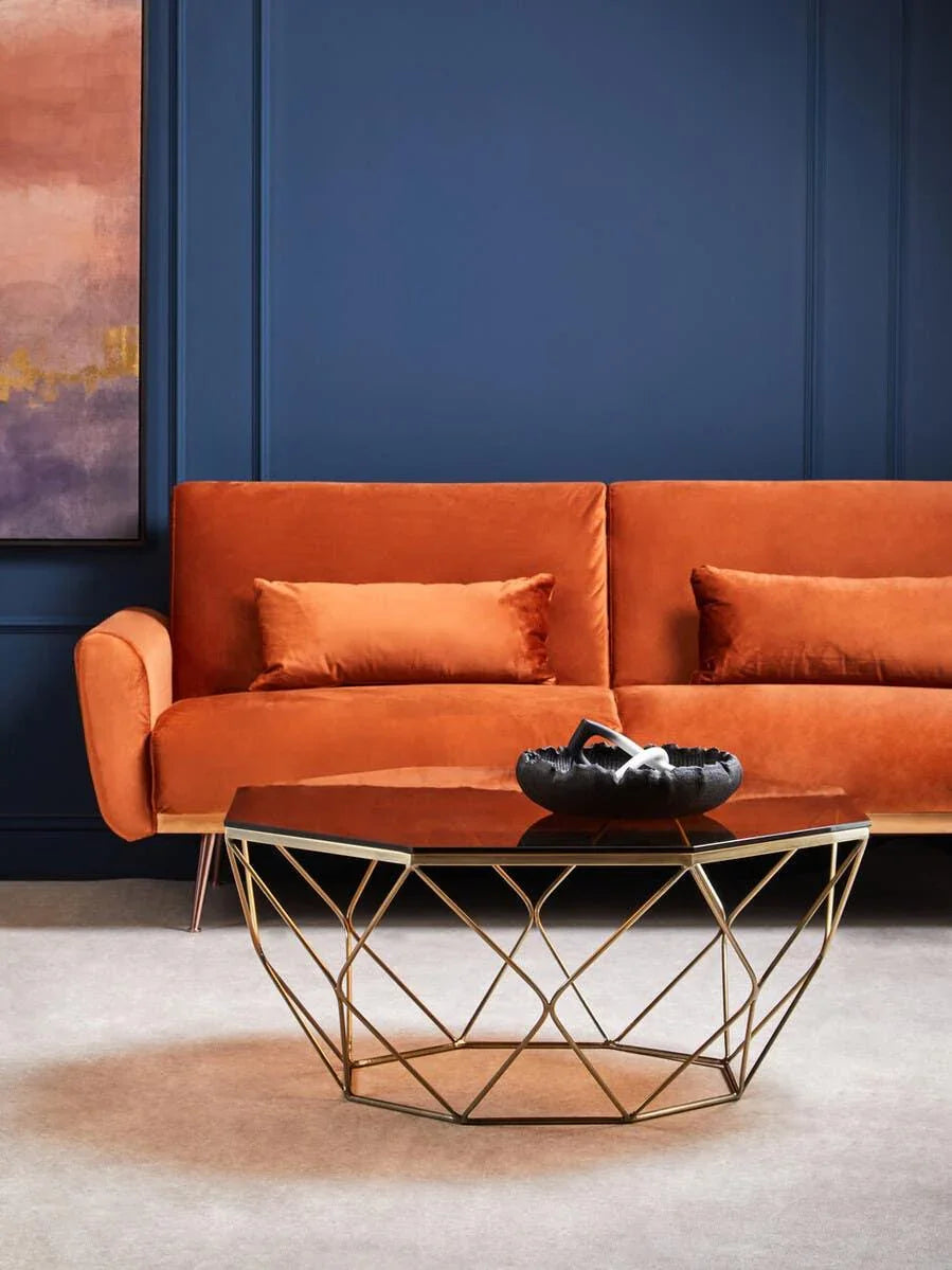 Orange velvet sofa with gold geometric coffee table in modern living room