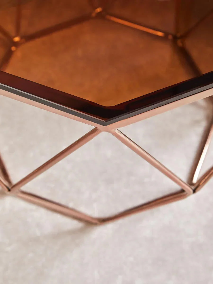 Copper geometric side table with glass top close-up on metal frame and tabletop