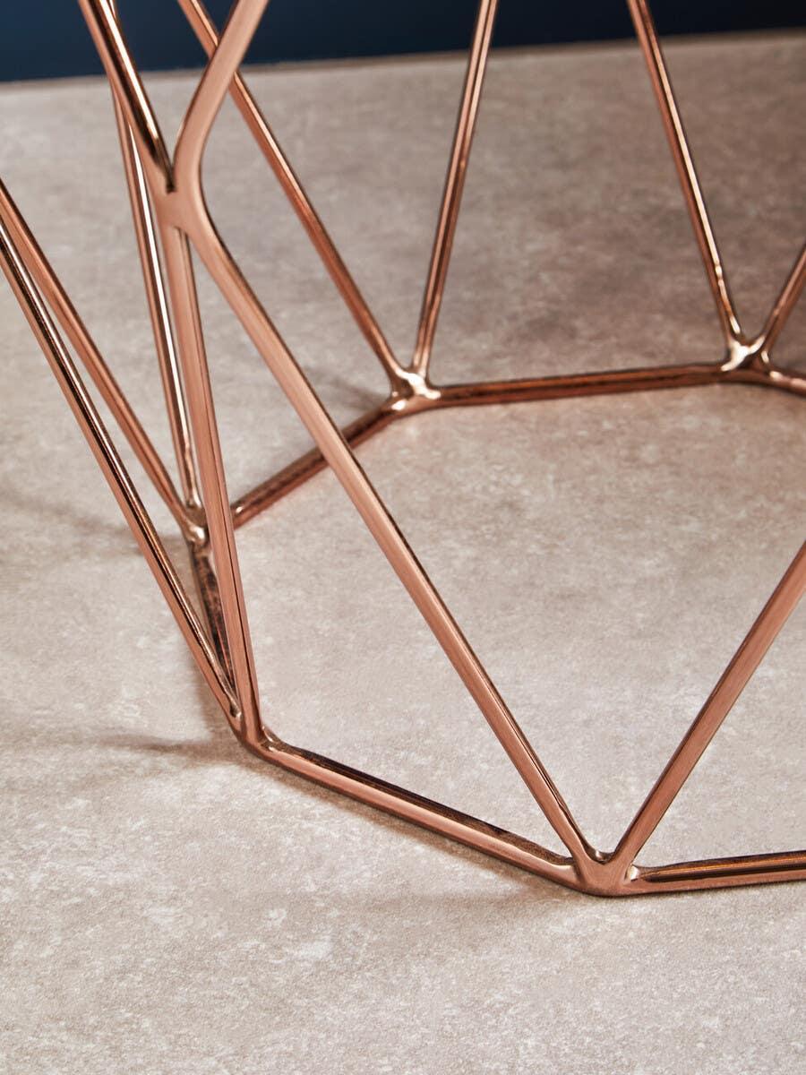 Copper metal geometric side table base on light stone floor