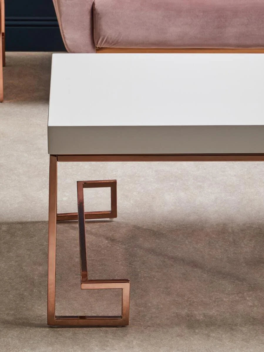 White coffee table with geometric rose gold metal legs on beige carpet