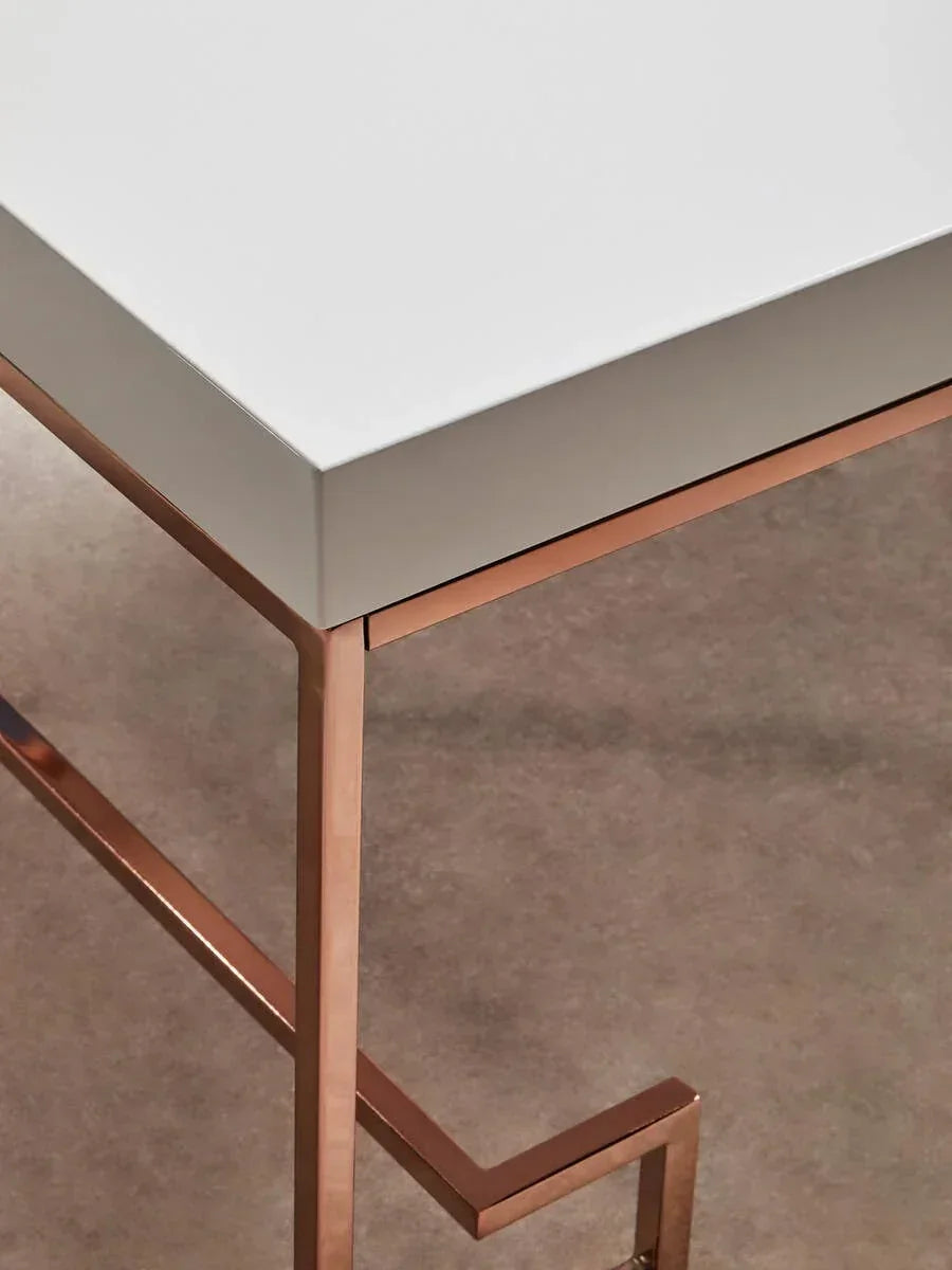 White tabletop with copper metal legs, modern side table corner on neutral carpet