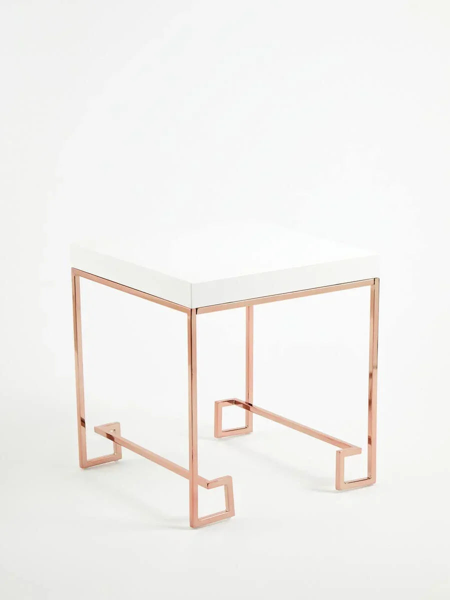 Modern side table with white top and rose gold metal frame on white background